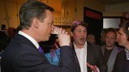 British Prime Minister David Cameron sinks a pint of Guinness.