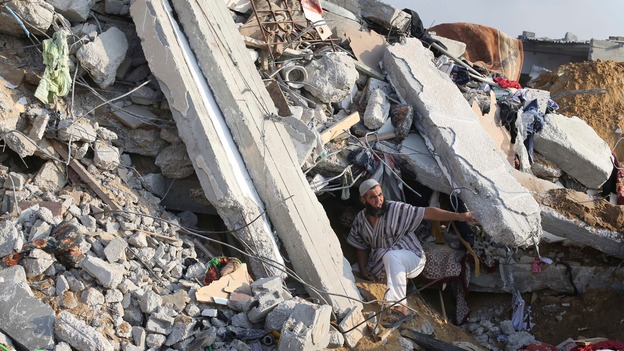 A Palestinian man searches for victims under the rubble of a house in Rafah, in the southern Gaza strip.