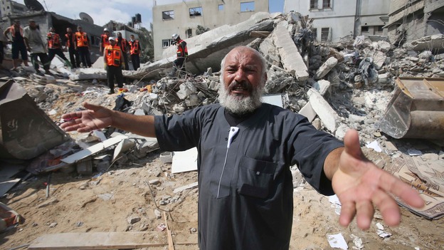 A Palestinian man reacts as rescue workers search for victims under the rubble of a house in Khan Younis, in southern Gaza.