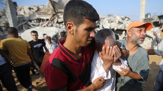 A Palestinian man reacts as people search for victims under the rubble of a house, which witnesses said as destroyed by an Israeli airstrike.