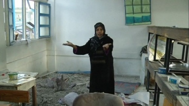 A woman assesses the wreckage.