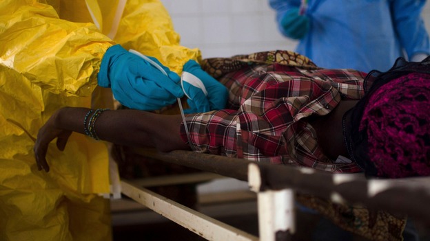 Medical staff take a blood sample from a suspected Ebola patient in Sierra Leone.