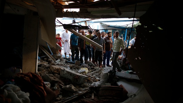 Palestinians inspect the ruins of a UN-run school used to shelter refugees in Gaza.