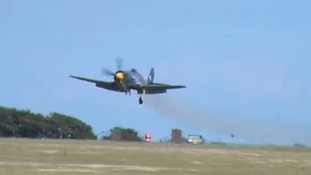 Smoke billows from The Royal Navy Sea Fury aircraft as it makes an emergency landing on the runway