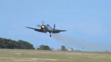 Smoke billows from The Royal Navy Sea Fury aircraft as it makes an emergency landing on the runway