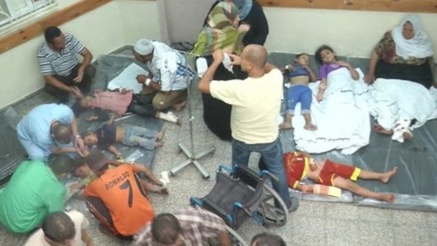Medics attempt to treat children and adults on the floor of Rafah hospital.