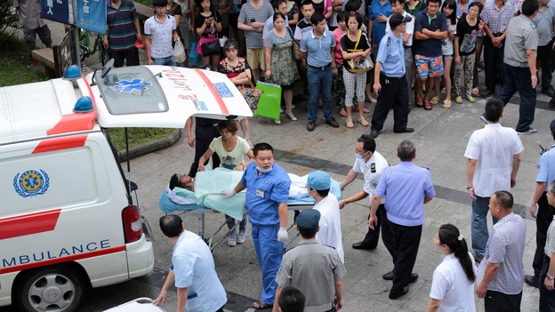Bystanders look on as injured victims of the blast are taken to hospital.