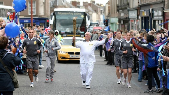 James Brown carries the Olympic flame between Marykirk and Brechin.