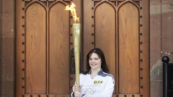 16-year-old Louise Fox holds the Olympic flame.