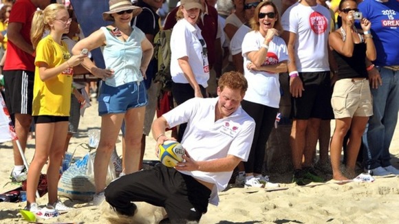 Harry scores a try as he plays touch rugby with children on Flamengo Beach