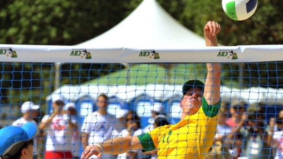 Harry plays a game of beach volleyball with children and teachers on Flamengo Beach