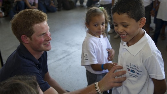 Prince Harry speaks to children during a visit to a health centre