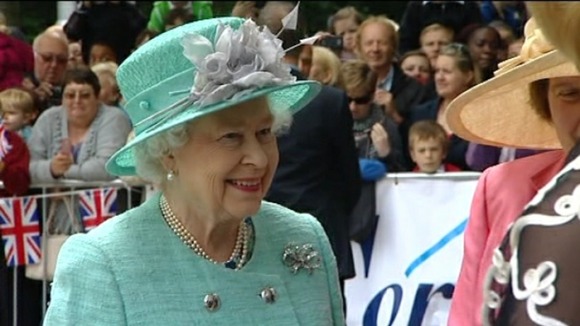 The Queen smiles at well-wishers as she arrives in Corby