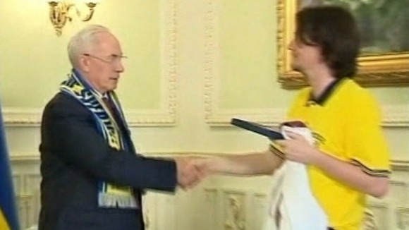 Euro 2012: Ola Sjostedt, head of the Swedish supporters club, gives Ukrainian PM his six pack of Swedish beer