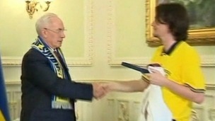 Euro 2012: Ola Sjostedt, head of the Swedish supporters club, gives Ukrainian PM his six pack of Swedish beer
