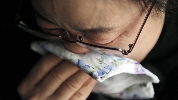 A woman cries during a ceremony for victims at Jyodoji temple in Rikuzentakata