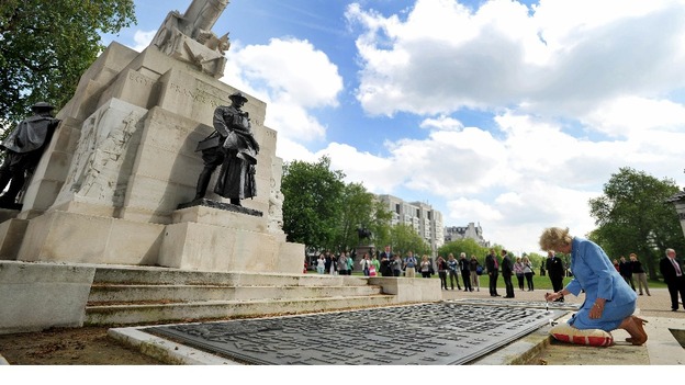 The Duchess of Cornwall kneels at the foot of the Royal Artillery Memorial on Hyde Park Corner.