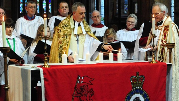 Reverend Canon Hilary Barber lights the last of the six candles to remember the six killed in Afghanistan