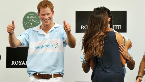 Prince Harry gives the thumbs up after being kissed by Brazilian supermodel Fernanda Mutta
