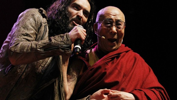 Russell Brand and the Dalai Lama on stage at The Manchester Evening News Arena.