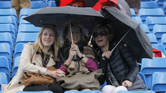 Spectators under umbrellas