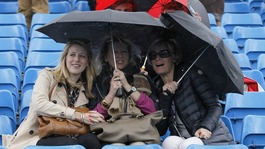 Spectators under umbrellas