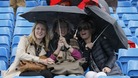 Spectators under umbrellas