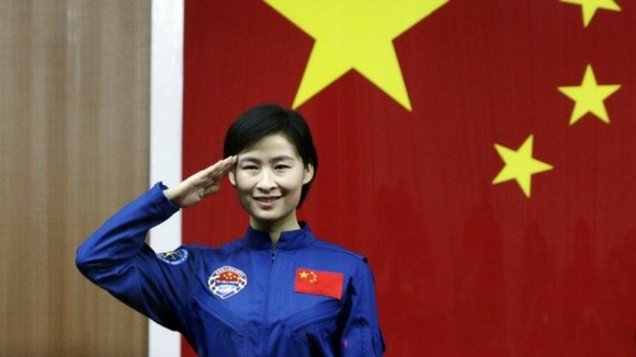 China's first female astronaut Liu Yang salutes during a news conference at Jiuquan Satellite Launch Centre