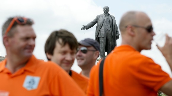 Holland fan have a drink in front of a statue of Lenin in Kharkiv prior to the match with Portugal.