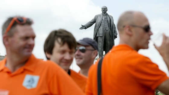 Holland fan have a drink in front of a statue of Lenin in Kharkiv prior to the match with Portugal.