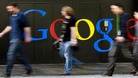 People walk past a logo next to the main entrance of the Google building in Zurich