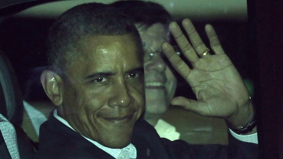 US President Barack Obama waves from his car after landing at the airport in Los Cabos