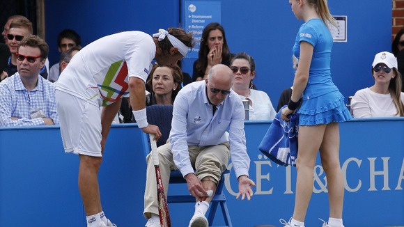 David Nalbandian looks on as the line judge tends to his injury.