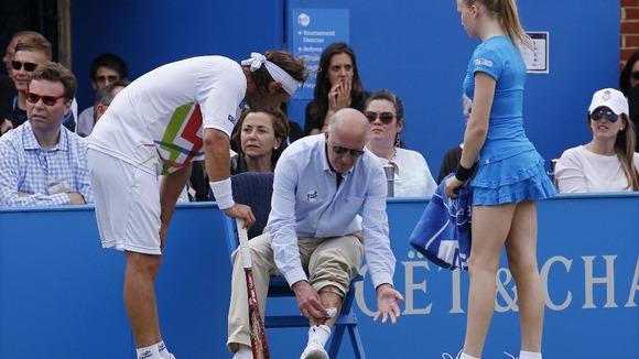 David Nalbandian looks on while the line judge tends to his injury.