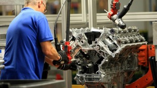 An engineer working on a Jaguar V8 engine