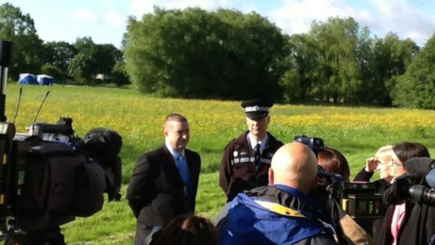 Police officers speak to reporters at the scene of today's search. 