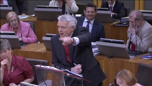 Carwyn Jones leaning on lectern