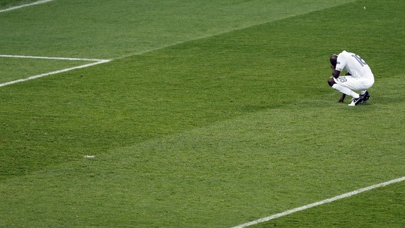 France captain Alou Diarra kneels in despair at the final whistle. 