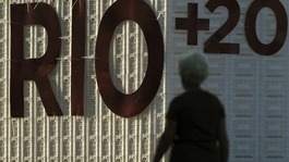 A woman walks past a signage of the Rio+20 United Nations Conference on Sustainable Development in Rio de Janeiro