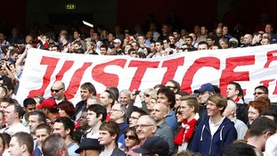 Liverpool fans hold up a banner relating to the Hillsborough disaster