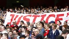 Liverpool fans hold up a banner relating to the Hillsborough disaster