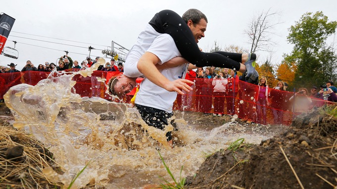 Seth Swanberg carries Lisa Swanberg through the water pit 