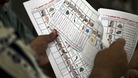 An official counts ballots for the presidential election after the polls were closed in Alexandria