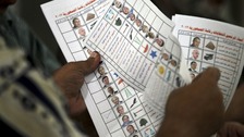 An official counts ballots for the presidential election after the polls were closed in Alexandria