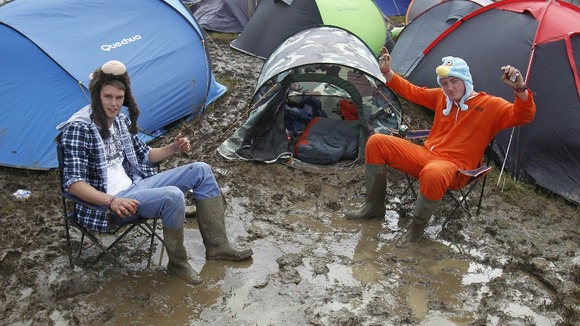 Blaise Franklin (left) and Nathan Mursall wallow in the mud at the campsite at the Isle of Wight Festival.