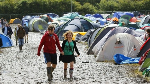 Festivalgoers trudge through the mud in Newport.