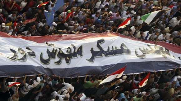 Supporters of the Muslim Brotherhood's presidential candidate Mohamed Morsi surround a giant banner