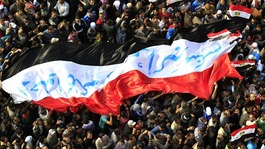Egyptian protesters march with a huge flag during a rally at Tahrir Square in November 2011