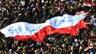Egyptian protesters march with a huge flag during a rally at Tahrir Square in November 2011