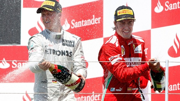 Ferrari Formula One driver Fernando Alonso, from Spain, right, celebrates his victory next to Mercedes driver Michael Schumacher, left.